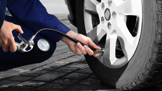 Person checking the tyre pressure 