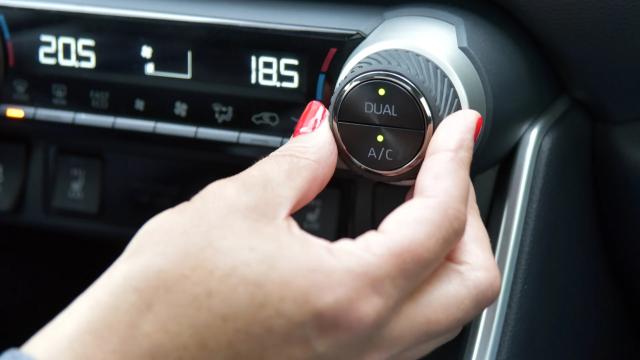 Women turning AC in her car