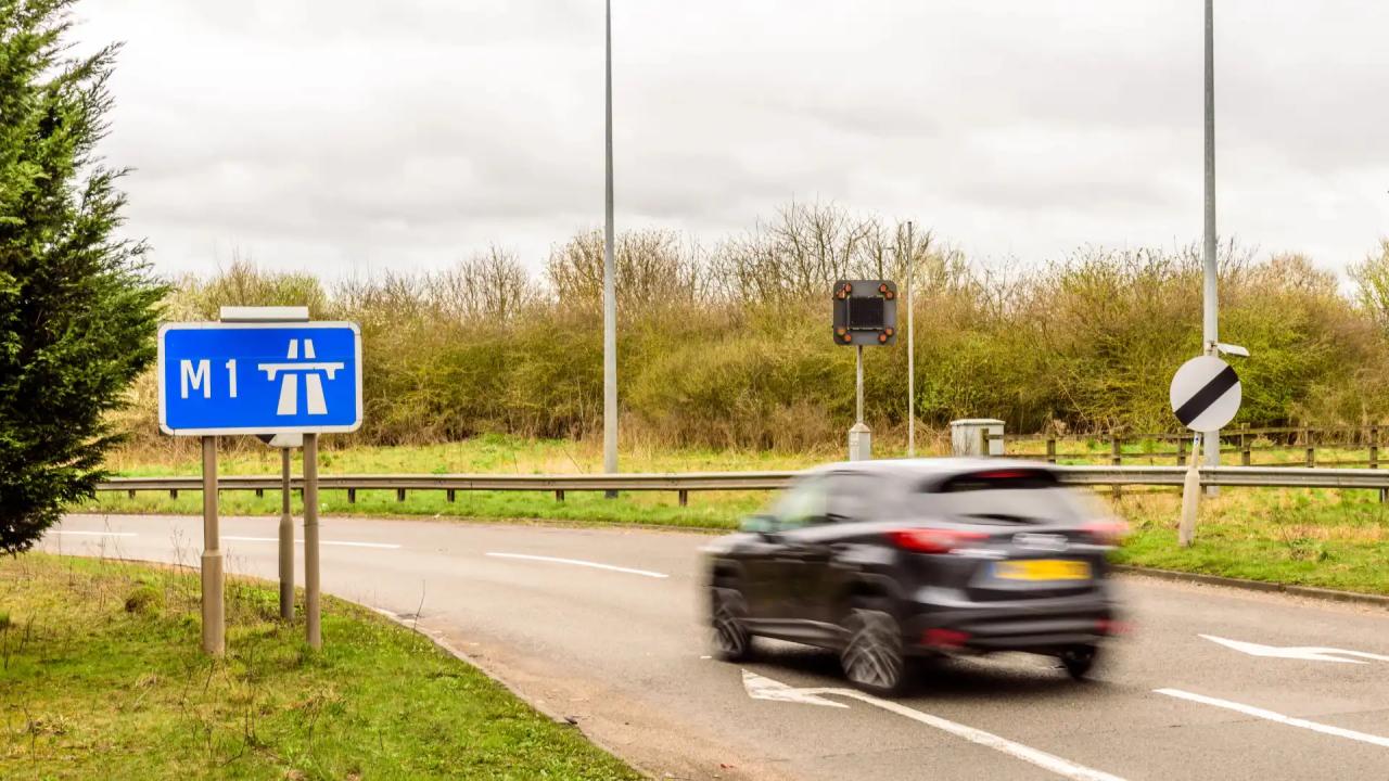 Car driving past a sign for the M1 motorway