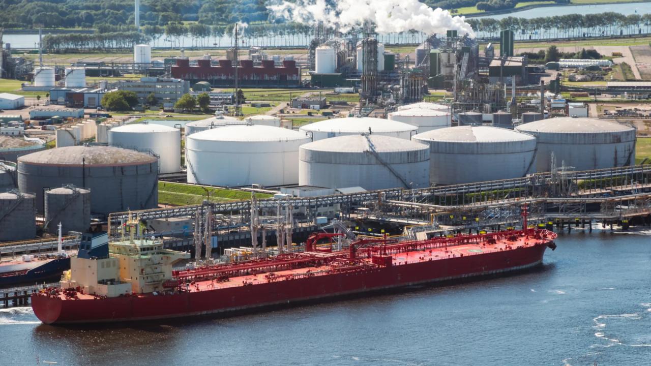 Oil tanker moored at a oil terminal with fuel storage silos